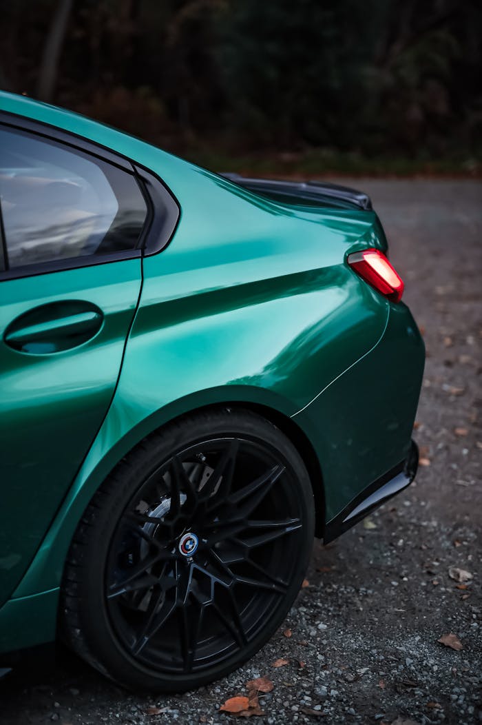 Elegant green car showcasing luxury and modern design with selective focus on rear details.